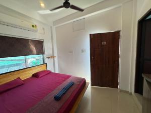 a bedroom with a bed with purple sheets and a ceiling fan at Happy Homes by Yoga & Smiles, Upper Tapovan in Rishīkesh +6 photos
