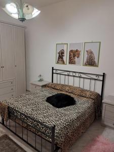 Dormitorio con cama con manta de leopardo en B&b Mythos, en Tuglie