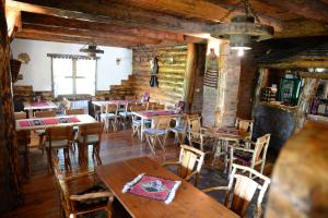 a restaurant with wooden tables and chairs in a room at Motel Nacionalni Restoran Ognjiste in Koruge