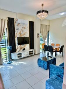 a living room with a tv and a table and chairs at EQAMEL Homestay in Sandakan