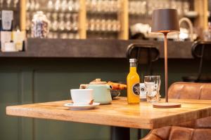 una mesa con una botella de vino y una copa en Un grain d'folie, en Villié-Morgon