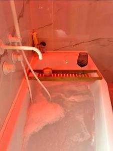 bañera llena de agua con manguera en B&b Mythos, en Tuglie