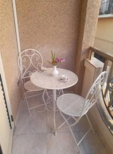 - Balcón con mesa blanca y sillas en B&b Mythos, en Tuglie