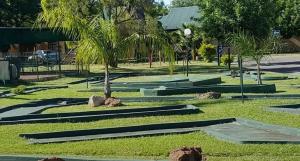 a park with palm trees and rocks in the grass at Pendleberry Grove 90 in Bela-Bela