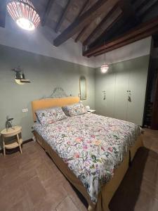 een slaapkamer met een groot bed met een sprei met bloemen bij Villa Il Pensierino in Manciano