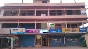 Hotel O Eco guest house في Gauhāti: مبنى طويل به لافتات أمامه
