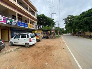 Hotel O Eco guest house في Gauhāti: سيارة بيضاء متوقفة على جانب شارع