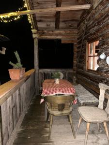 un tavolo e delle sedie sul portico di una baita in legno di Miniferienwohnung für unkompliziertes Naturliebhaberpärchen a Payerbach