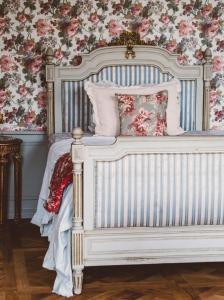 Château-VerdunにあるChateau de Gudanesの花柄の壁紙を用いたベッドルームの白いベッド1台