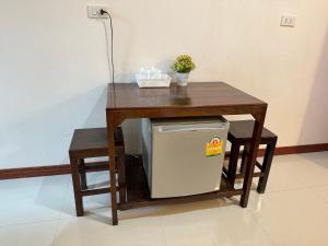 a wooden table with a small refrigerator under it at บ้านในฝัน เชียงคาน in Chiang Khan +2 photos