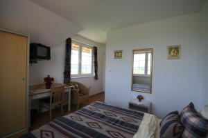 a bedroom with a bed and a desk in it at Dworek Łeba in Łeba
