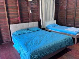 a bedroom with two beds with blue pillows at Hotel O Sri Ayu Inn in Kampung Gurun +20 photos