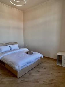 a bedroom with a bed with a white blanket and a table at Miassine Boutique Hotel in Gyumri +5 photos