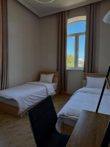 two beds in a room with a window at Miassine Boutique Hotel in Gyumri