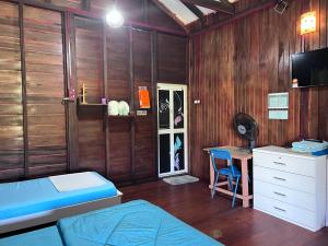 a bedroom with a bed and a desk with a computer at Hotel O Sri Ayu Inn in Kampung Gurun