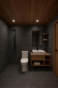 a bathroom with a toilet and a sink at Teak house in a forest above the beach 