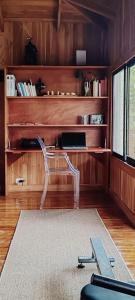 a room with a chair and a desk with books at Teak house in a forest above the beach 