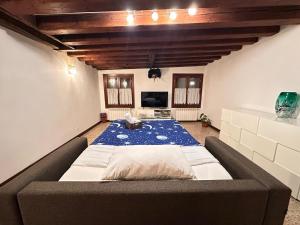 a large bed in a room with a blue carpet at Ca' Della Torre, a 5 min da Rialto in Venice