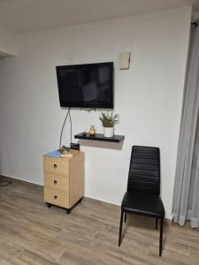 a room with a chair and a tv on a wall at Casa Branco in Borba