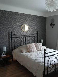 a bedroom with a black bed with a round mirror at La Gilbertine in Louze