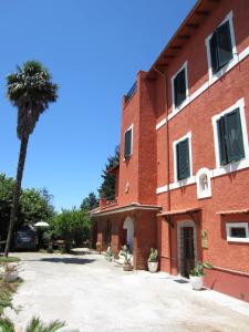 a red brick building with a palm tree next to it at B&B Tobia in Cave