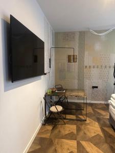 un salon avec une table et une télévision sur un mur dans l'établissement C7 studio industrial, à Brno