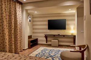 a hotel room with a flat screen tv on a striped wall at 7 Gates Boutique Hotel Pyramids in Cairo