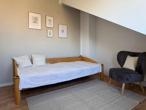 a bedroom with a bed and a chair at SkyLoft Rheinland in Bornheim