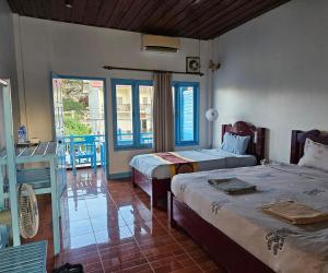 a bedroom with two beds and a balcony at west water hostel in Vang Vieng