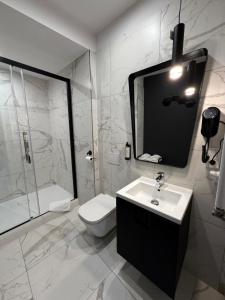 a bathroom with a sink and a toilet and a mirror at Apartamenty Prestiż Podfigórna in Koszalin +34 photos