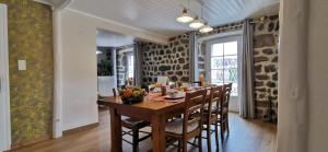 Un comedor con mesa y sillas de madera. en La Maison d'Amélina, en Séneujols