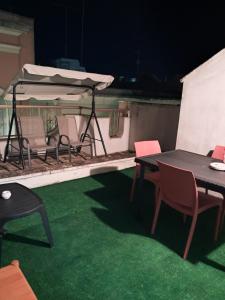 Un patio con mesas y sillas y una sombrilla. en B&b Mythos, en Tuglie