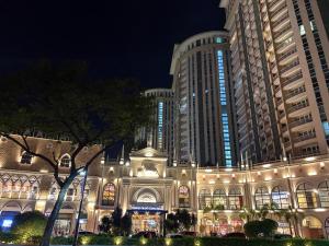 a large building at night with tall buildings at Modern 1 bedroom spacious apartment with Venice Grand Canal View in Manila