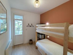 zwei Etagenbetten in einem Zimmer mit Fenster in der Unterkunft L'ancienne Poste in Fort-Mahon-Plage