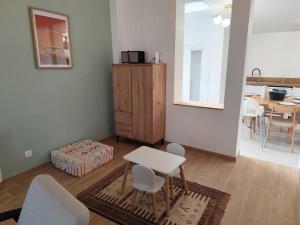 ein Wohnzimmer mit einem Tisch und Stühlen sowie einem Schrank in der Unterkunft L'ancienne Poste in Fort-Mahon-Plage + 7 Fotos