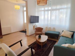 ein Wohnzimmer mit Sofa, Sesseln und Fernseher in der Unterkunft L'ancienne Poste in Fort-Mahon-Plage