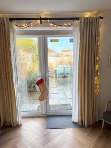 a sliding glass door with a santa hat on it at Sanderling House, walk to beach in Earnley