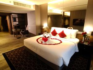 a hotel room with a bed with a swan on it at Ayathorn Bangkok in Bangkok