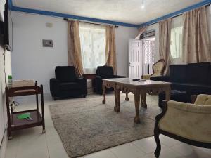 a living room with a table and chairs at Blue Waves Apartments in Mombasa