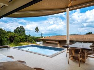 an outdoor patio with a swimming pool and a table at Homey 2Br Villa Apricot Close to Beach Sea View in Plai Laem