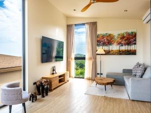 a living room with a couch and a table at Homey 2Br Villa Apricot Close to Beach Sea View in Plai Laem