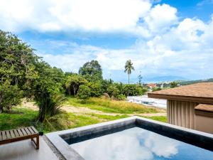 a swimming pool with a bench next to a house at Homey 2Br Villa Apricot Close to Beach Sea View in Plai Laem