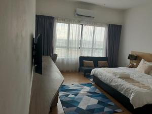 a bedroom with a bed and a tv and a couch at AmmarLeen Guest Suite in Kota Bharu