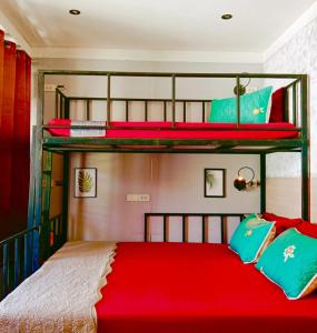 COZY Bangkok BM B&B في Amphoe Phra Khanong: غرفة نوم بسريرين بطابقين مع شراشف حمراء