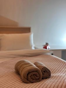 a bed with two rolled towels on it at Miassine Boutique Hotel in Gyumri