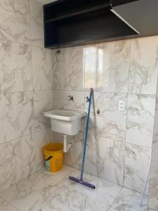 a bathroom with a sink and a mop at Apartamento in Espirito Santo Do Pinhal +3 photos