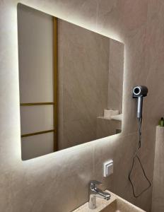 a bathroom mirror with a hair dryer on a wall at The Palm hotel & spa in Almaty
