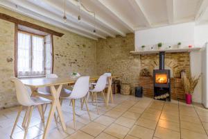 a dining room with a table and chairs and a fireplace at Maison de campagne rénovée proche Argenton Sur creuse in Célon