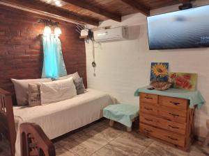 ein Schlafzimmer mit einem Bett, einer Kommode und einem TV in der Unterkunft La Escapada San Pedro in San Pedro