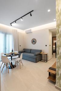a living room with a blue couch and a table at Chania Experience Residence in Chania